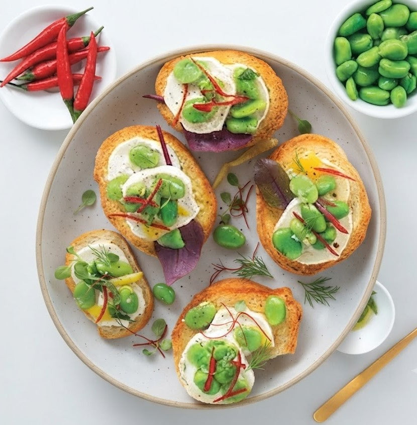 Bruschetta con formaggio di capra alle erbe, fave e peperoncino
